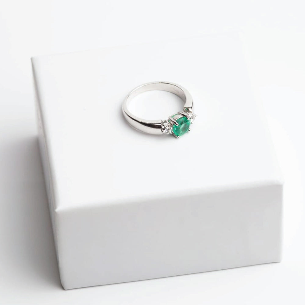 Anello Solitario con Smeraldo Colombiano e Diamanti Laterali – Oro Bianco 18 kt